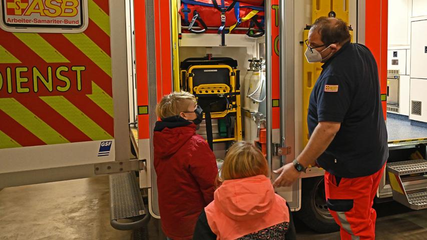 Mila und Leon lassen sich den Rettungswagen genau erklären.